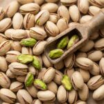 Kalorien von Pistazien: Gesunder Snack? Frische Pistazien mit Schalen und grünen Kernen von oben